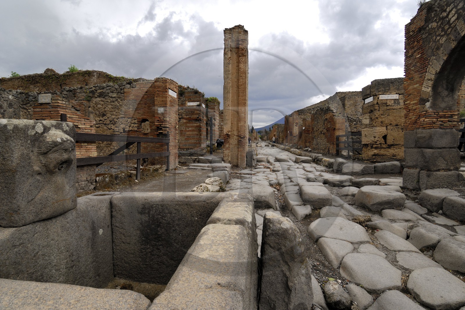 Italie, Campanie, Pompei, site archéologique classé Patrimoine Mondial de l'UNESCO, ancienne rue pavée de la ville et fontaine