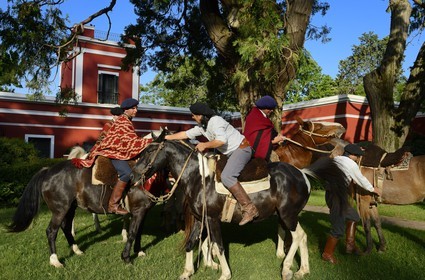 Argentine, province de Buenos Aires, San Antonio de Areco, groupe de gauchos à cheval devant l'estancia La Bamba de Areco