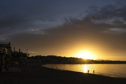 France, Pyrenees Atlantiques, Basque Country, Saint Jean de Luz, walkers on the Grande Plage and the coast of Ciboure in the bay in the background