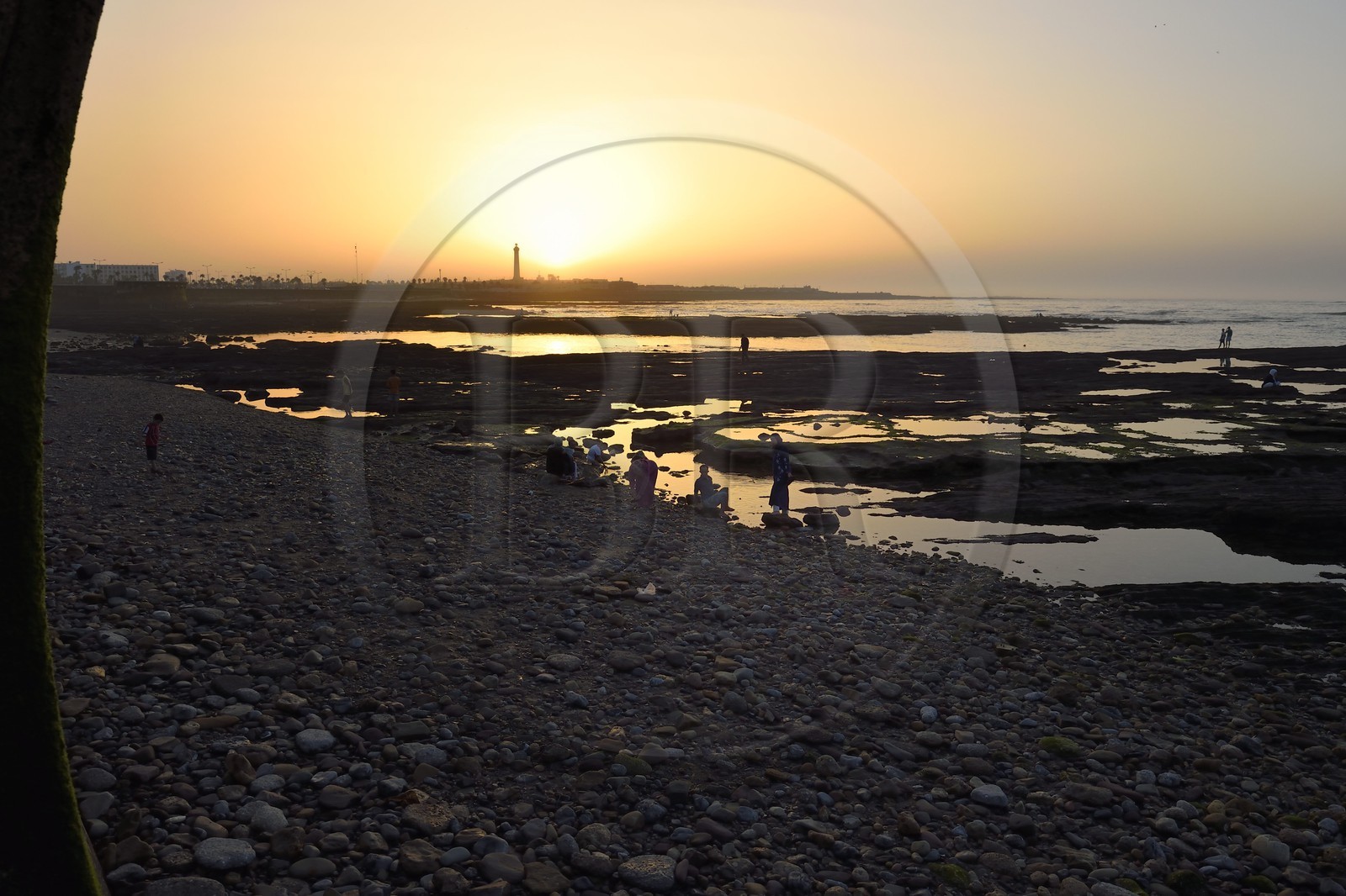 Maroc, Casablanca, la plage de galet de La Corniche et le phare d'El Hank en arrière plan