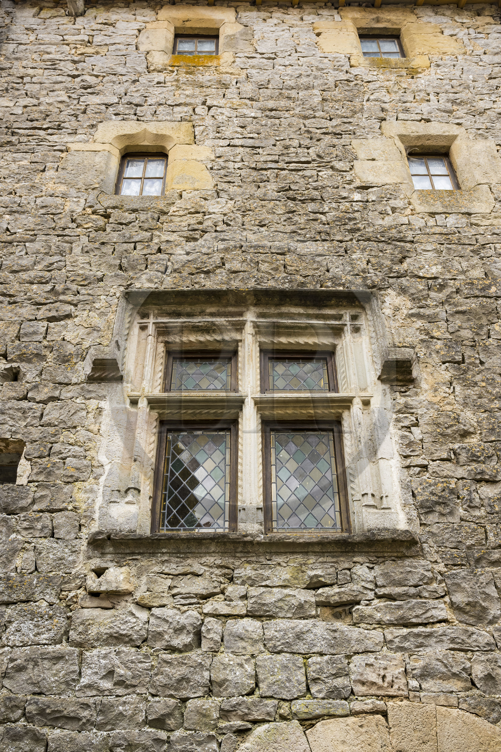 France, Aveyron (12), parc naturel régional des Grands Causses, le fort cistercien de Saint-Jean-d’Alcas, le Grenier de la Rente servait autrefois à entreposer les redevances de l'abbesse de Nonenque, fenetre à croisée Renaissance sur la facade de maison médiévale typique de l’architecture caussenarde