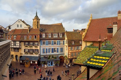 France, Haut Rhin, Colmar, gabled houses and wood-framed houses in Grand Rue with Christmas decorations, on the right the former douane or customs control edifice (Koifhus) and the Saint-Martin collegiate church in the background