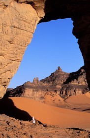 Libye, région du désert, Le Fezzan (Sahara), touareg sous l'arche (en grès) de Afazedjar dans la Tadrart Akakus