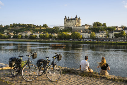 France, Maine-et-Loire, Loire valley listed as World Heritage by UNESCO, Saumur, cycling on the banks of the Loire, the castle and the church of Saint-Pierre on the banks of the Loire river