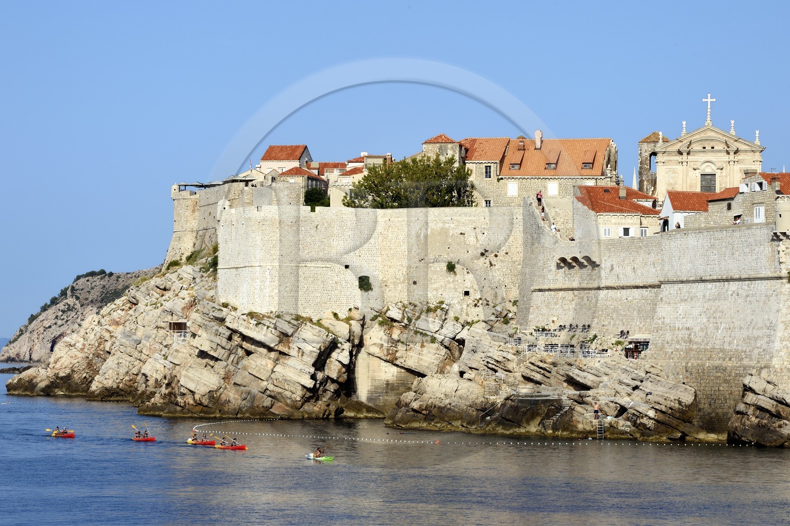Croatie, Dalmatie, cote dalmate, Dubrovnik, centre historique classé Patrimoine Mondial de l'UNESCO, kayaks passant au pied des remparts coté mer et l'église Saint Ignatius (Saint Ignace) en arrière plan