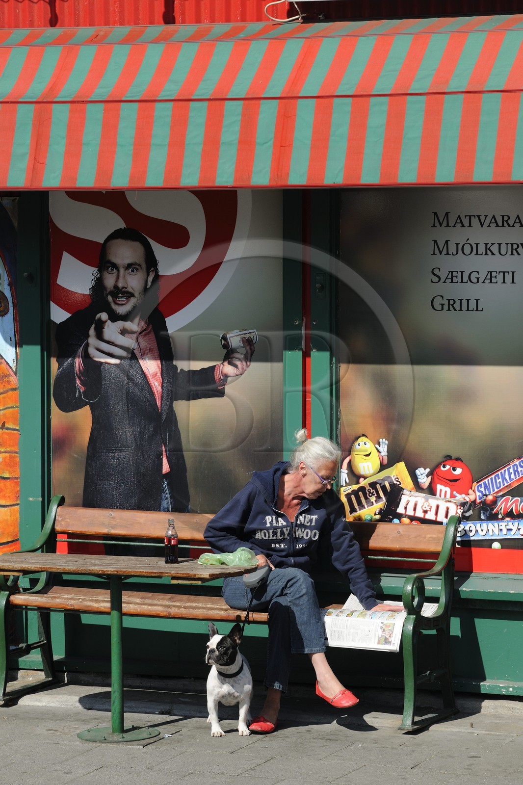 Islande, Reykjavik, lecture du journal devant une épicerie