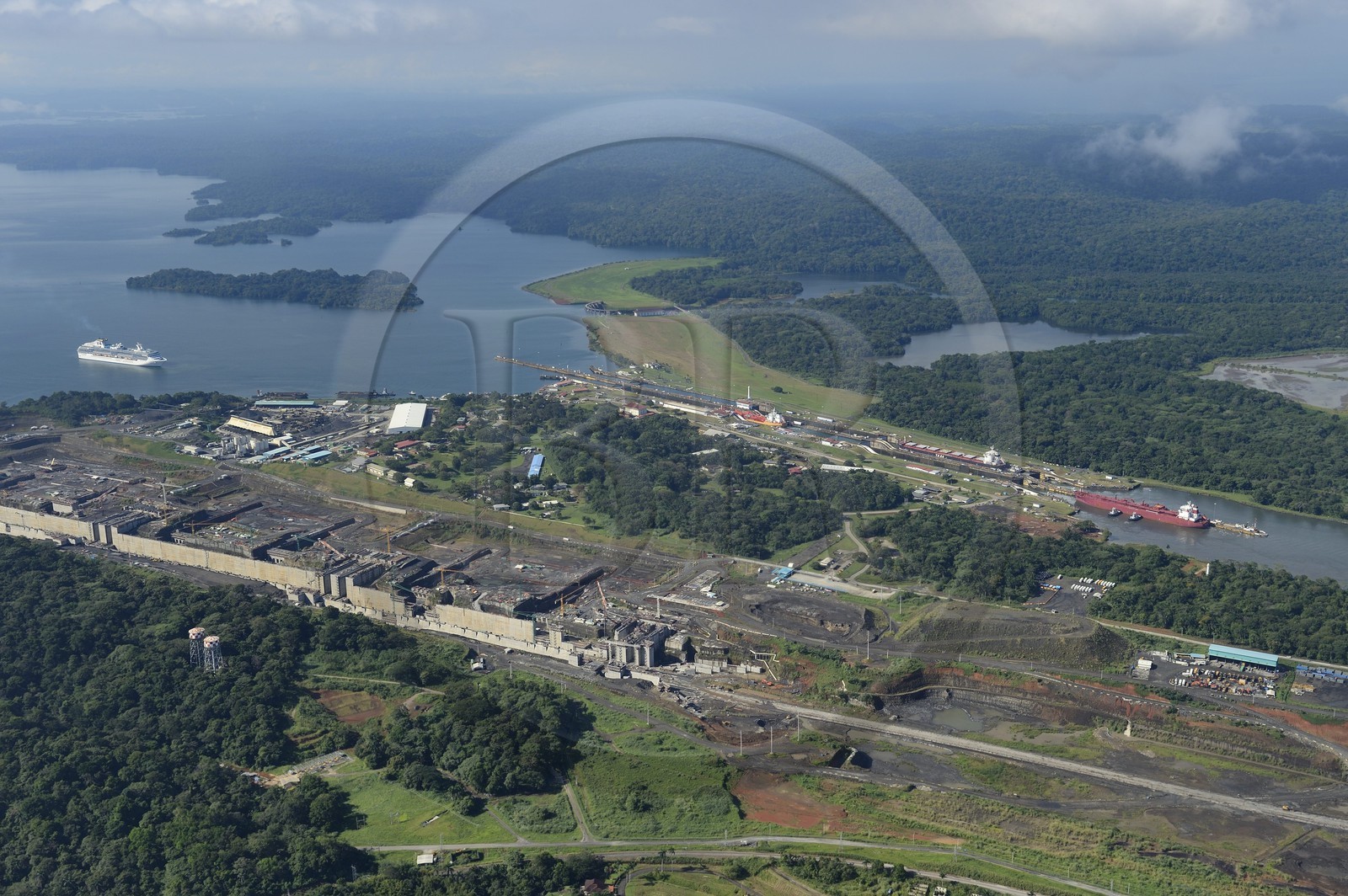 Panama, province de Colon, Canal de Panama, cargo Panamax passant les écluses de Gatun, le chantier des nouvelles écluses sur la gauche et le lac Gatun en arrière plan (vue aérienne)