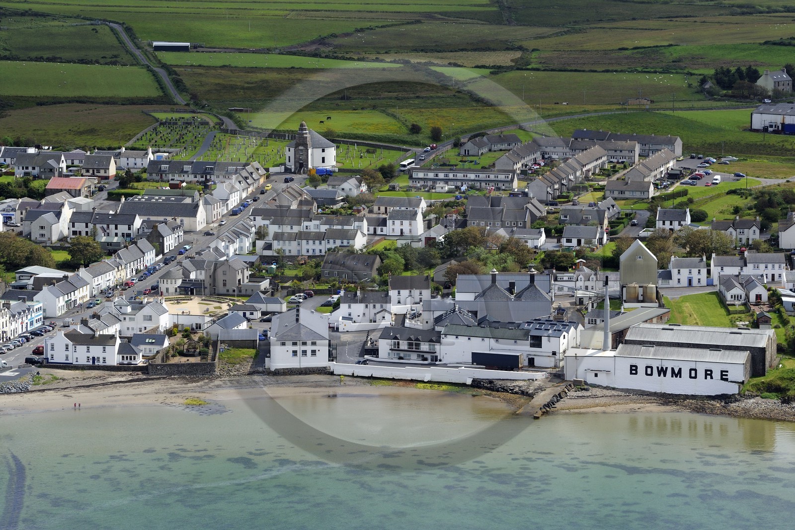 United Kingdom, Scotland, Inner Hebrides, Islay Island, Bowmore and the Bowmore Scotch whisky distillery on the eastern shore of Loch Indaal and the main street leading to the Round Church which was built in a circular shape to prevent the devil from hiding in a corner (aerial view)