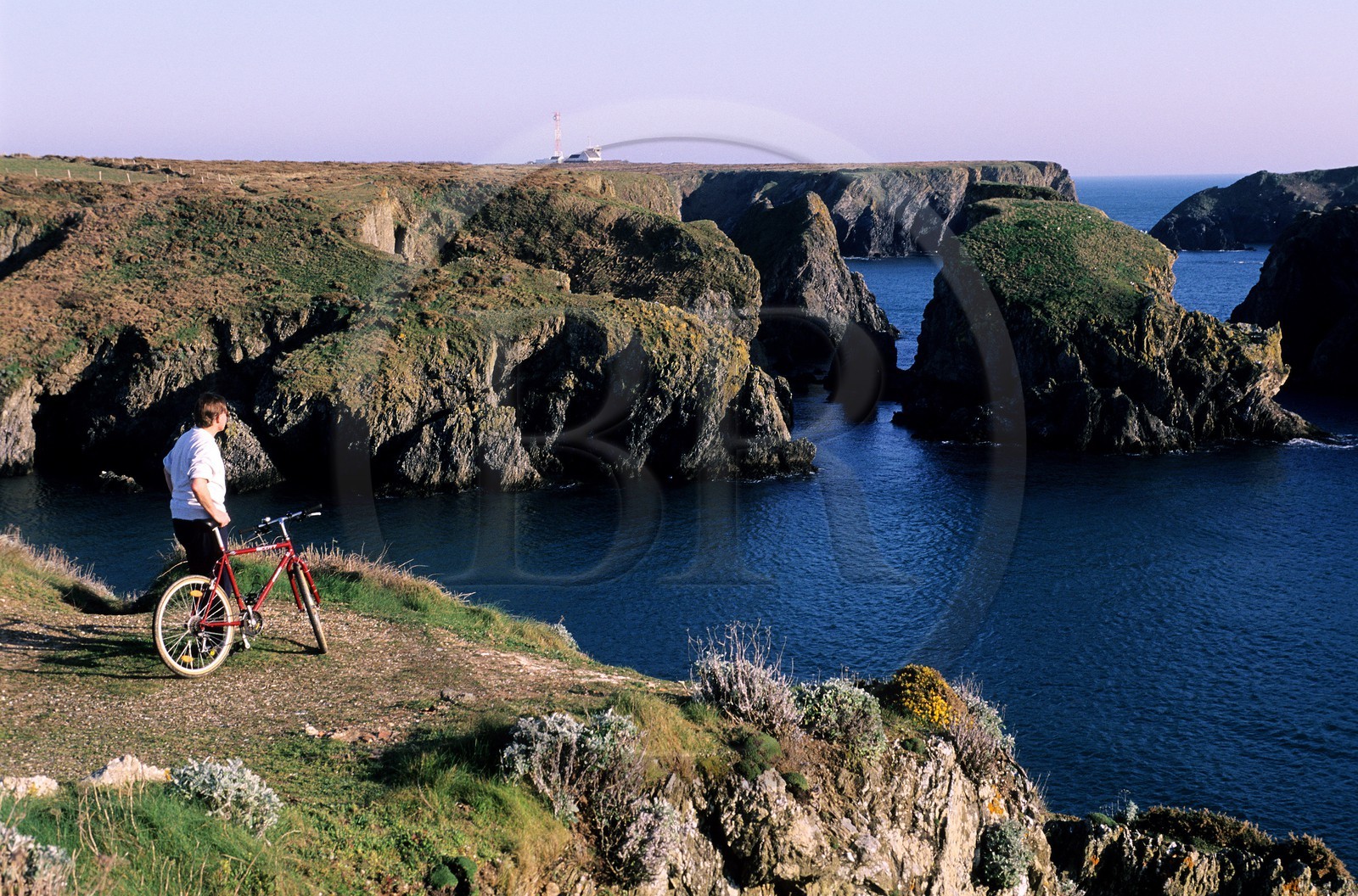 France, Morbihan (56), Belle-Île, un cycliste admirant le chaos rocheux de Port Goulphar