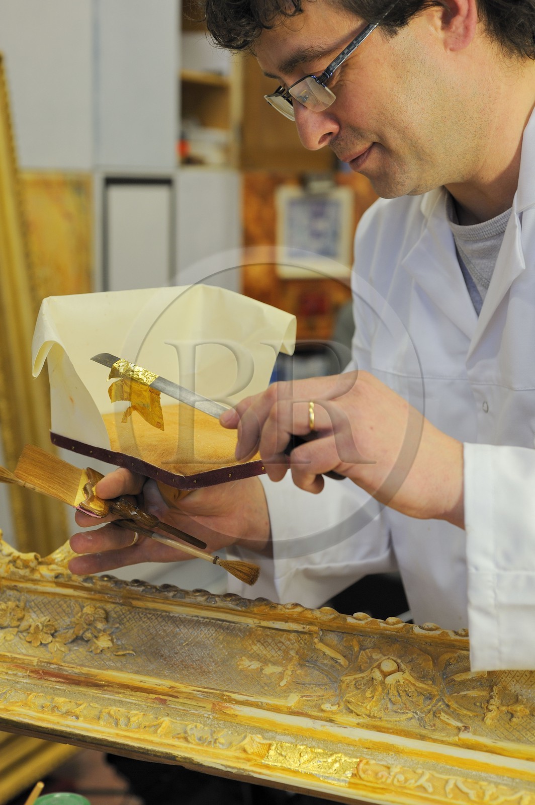 France, Yvelines (78), château de Versailles, ateliers de restauration du château, atelier de dorures, Laurent Hissier travaillant sur un cadre de tableau