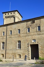 France, Haute Loire, Livradois Forez Regional Natural Park (Parc naturel régional Livradois-Forez), the Chaise-Dieu abbey, a brother of Saint John entering the abbey, the Clementine tower in the background