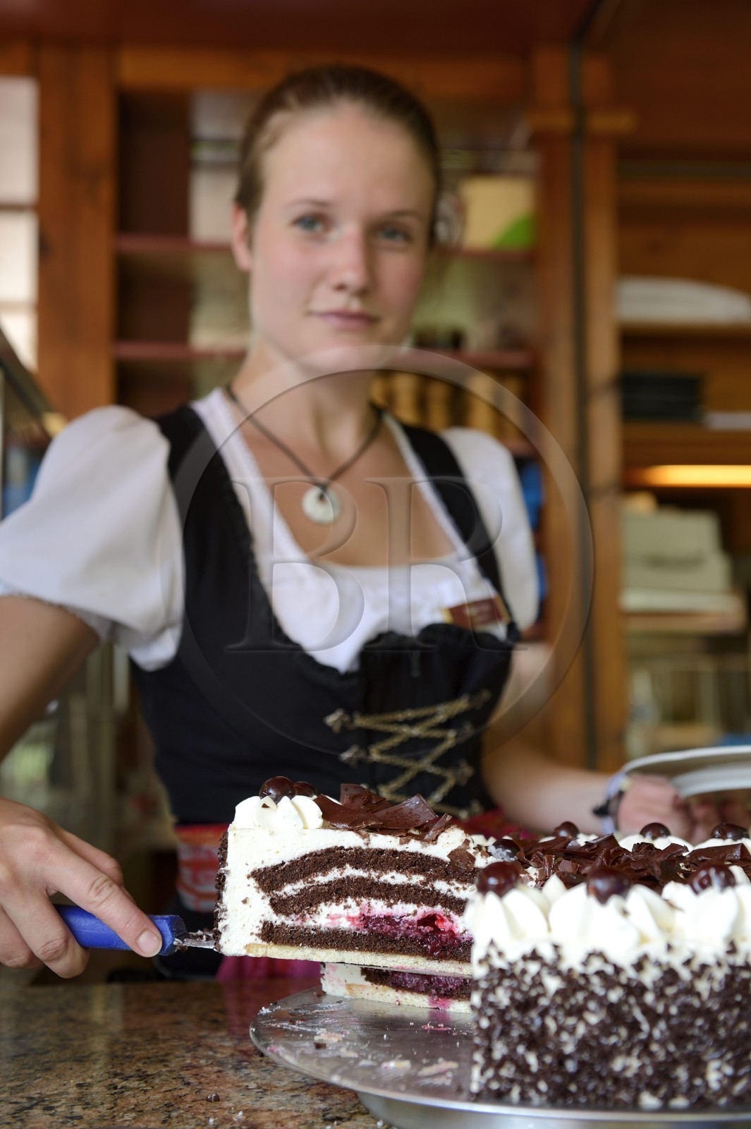 Germany, Baden-Wurttemberg, Durbach, Rebstock Hotel and Restaurant, waitress in traditional costume, Black Forest cake (Schwarzwälder Kirschtorte)