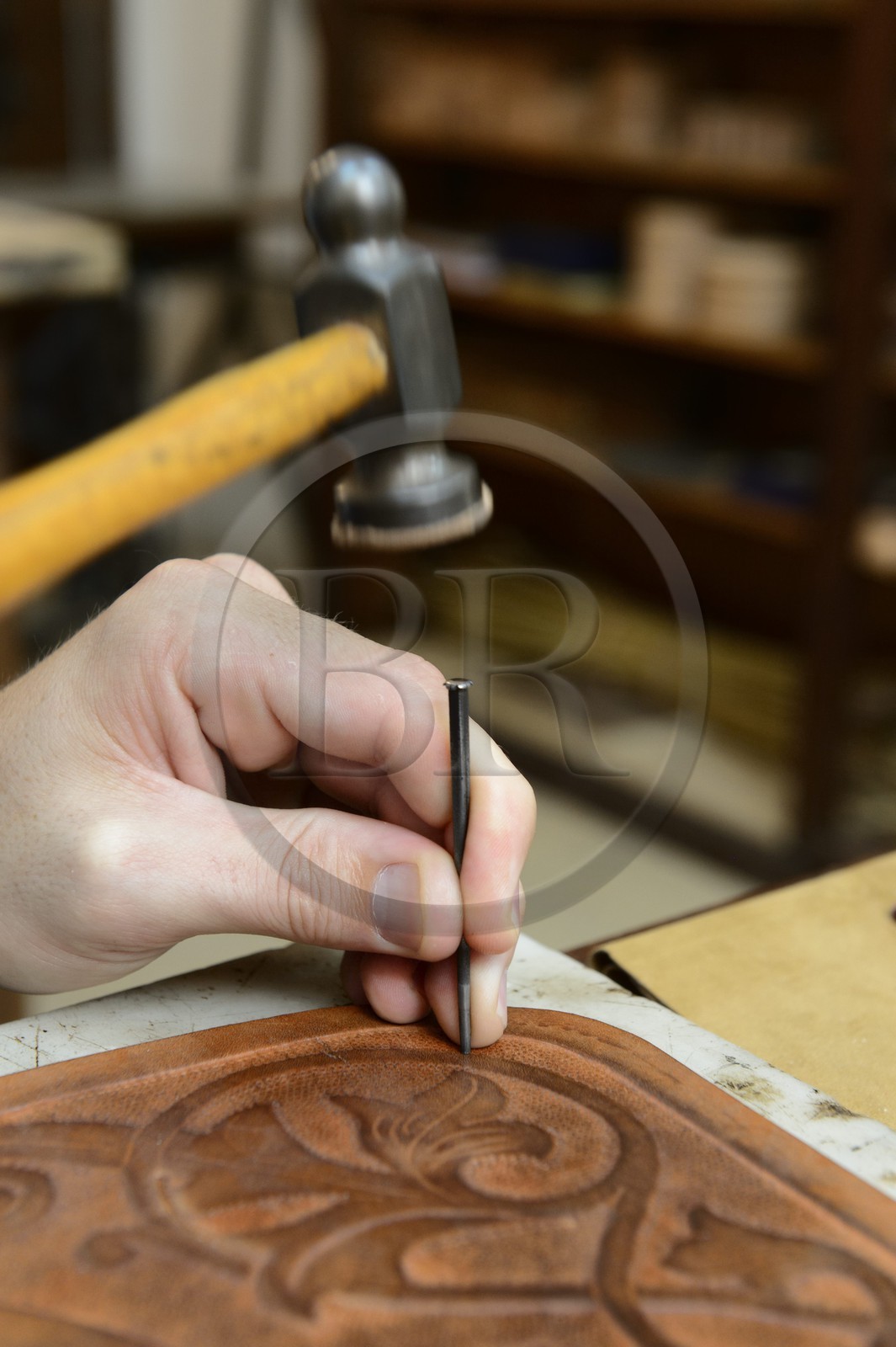 Argentina, Buenos Aires Province, San Antonio de Areco, workshop of the leather craftsman Martin Alvarez hammering the leather of a saddle piece