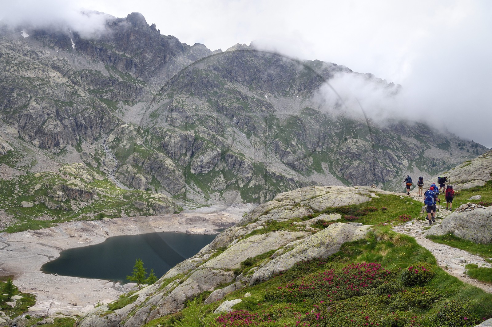 France, Alpes-Maritimes (06), parc national du Mercantour, vallée de la Valmasque, randonneurs sur le sentier de randonnée au dessus du lac Vert